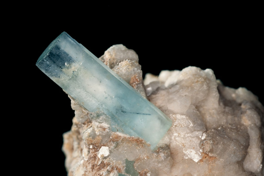 Raw aquamarine attached to a crystal.